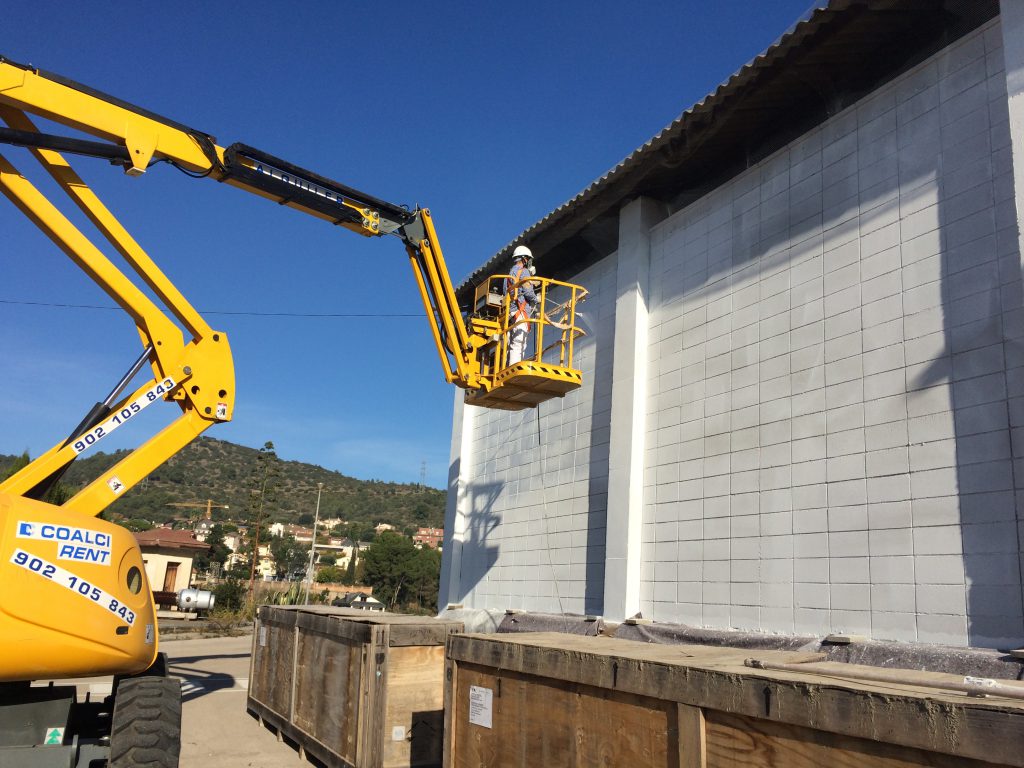 Pintando fachada en nave de Granollers